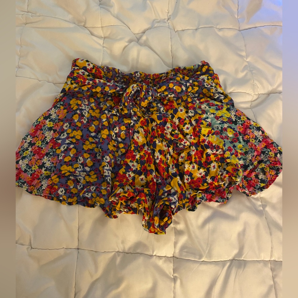 Flowy, stretchy, shorts that look like a skirt. Attached tie belt in front.